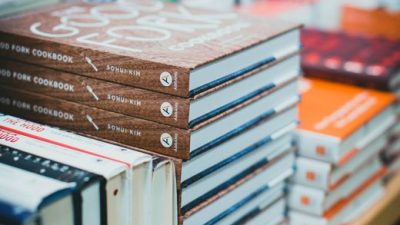 Close-up of various books stacked on a table in a bookstore, showcasing covers.
