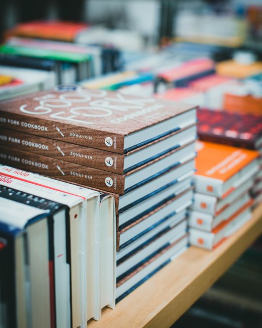 Close-up of various books stacked on a table in a bookstore, showcasing covers.