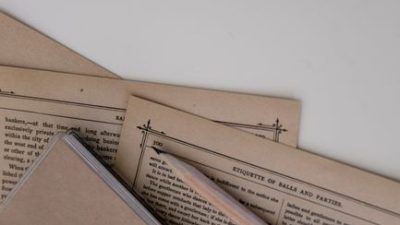An artistic flat lay of vintage stationery and pages against a white background.