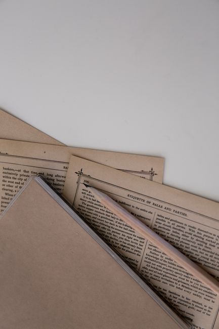 An artistic flat lay of vintage stationery and pages against a white background.