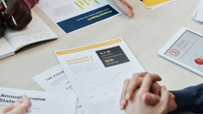Team members discuss data reports and statistics in a collaborative setting around a table.