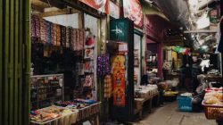 Traditional market aisle in Jakarta with colorful stalls and fresh produce, showcasing vibrant local culture.