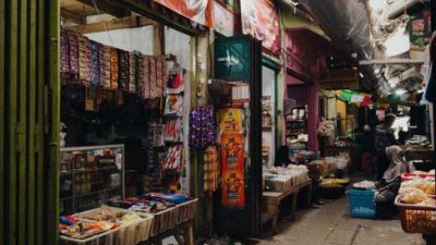 Traditional market aisle in Jakarta with colorful stalls and fresh produce, showcasing vibrant local culture.