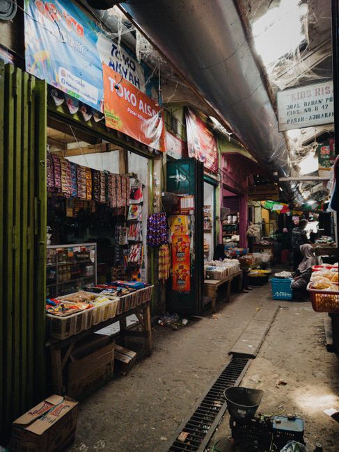 Traditional market aisle in Jakarta with colorful stalls and fresh produce, showcasing vibrant local culture.