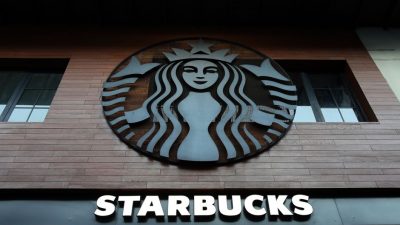 Low angle shot of Starbucks building exterior with logo and windows.