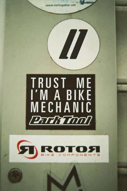 Concrete wall with various stickers representing inscription about mechanic service behind ribbed wall in town