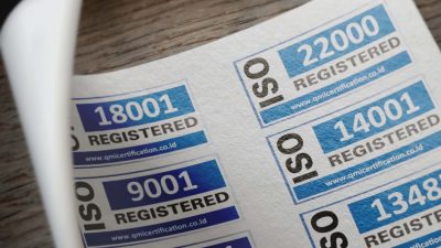 ISO certification stickers with registration numbers on paper.